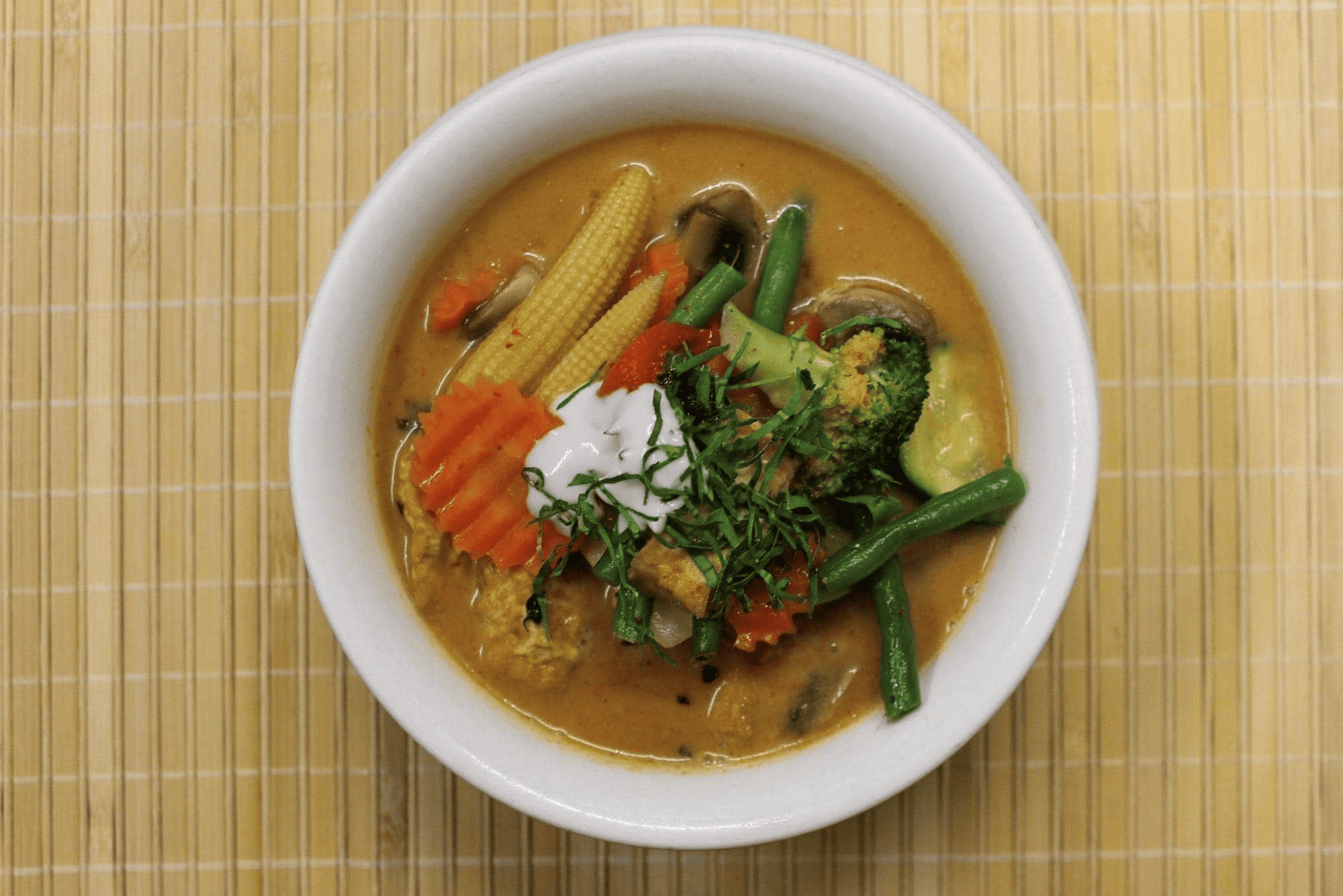 A bowl of rich and creamy Panang curry topped with crushed peanuts.