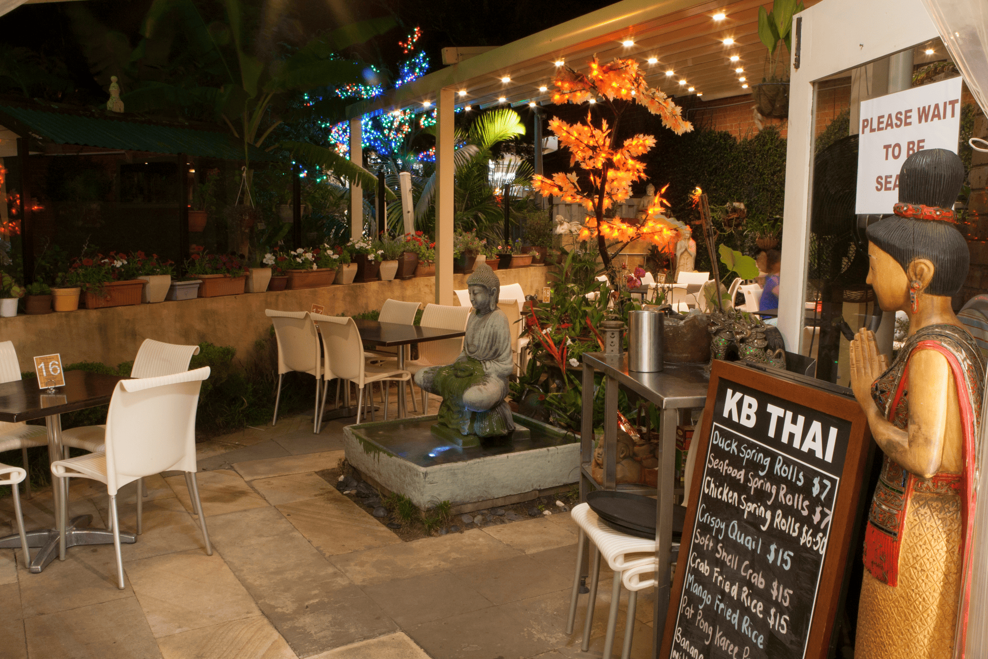 KB Thai Restaurant's outdoor seating with lights and Buddha statue.